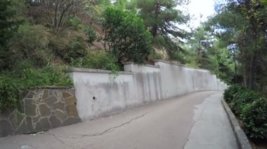 GURZUF, Ekim 2016: Kamera Aivazovsky, Ekim 2016 'da Gurzuf, Kırım' da bulunan Park Aivazovsky 'deki tırmanma tesisleriyle birlikte sabit bir taş duvara hareket ediyor