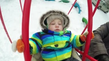 Çocuk kışın salıncak üzerinde