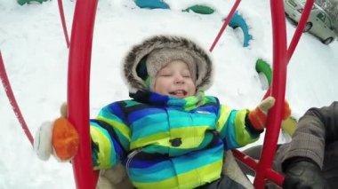 Çocuk kışın salıncak üzerinde