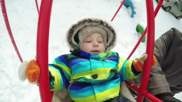 Niño en columpio en invierno — Vídeos de Stock