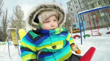 Çocuk kışın salıncak üzerinde