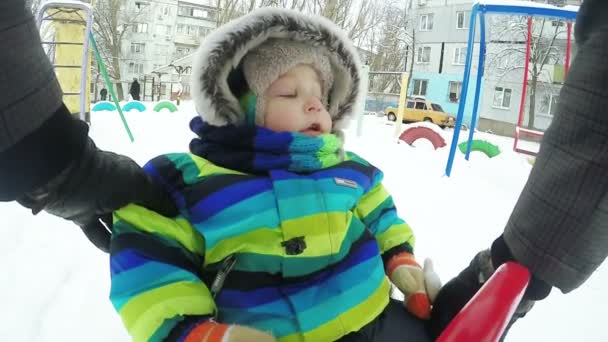 Child on swing in winter — Stock Video