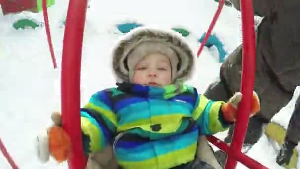 Niño en columpio en invierno — Vídeo de stock