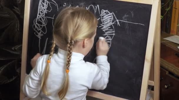 Little girl draws chalk on blackboard — Stock Video
