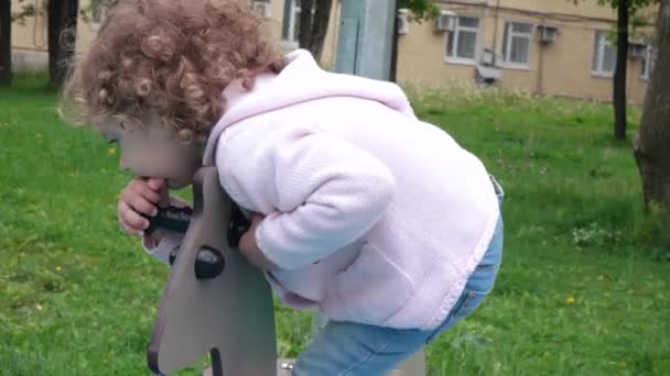 Ragazza cavalcando un cavallo di legno — Video Stock