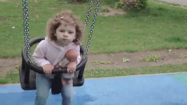 Chica montando en un columpio mamá — Vídeos de Stock
