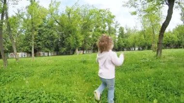 Çimenlerin üzerinde çalışan kız çocuk