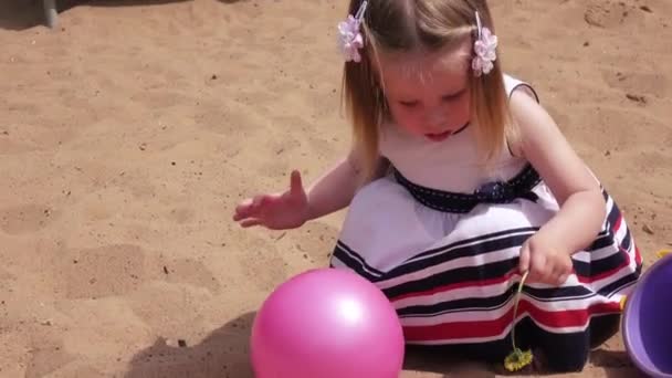 Klein meisje in een zandbak — Stockvideo