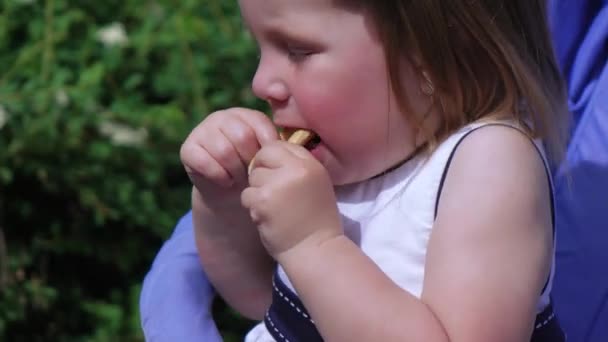 Девочка ест бублик — стоковое видео
