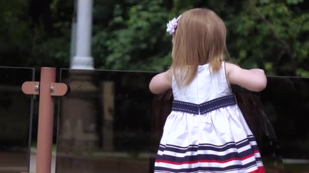 Girl child looking at the fountain — Stock Video