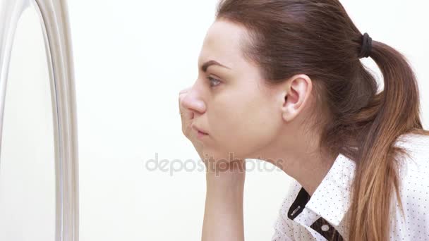 Девушка рисует лицо перед зеркалом — стоковое видео