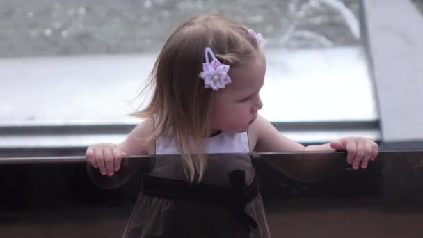 Девочка смотрит на фонтан — стоковое видео