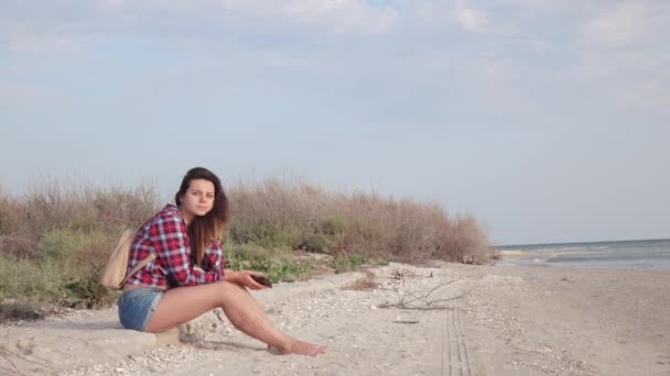 Flicka på stranden med telefon — Stockvideo