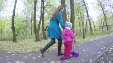 Anne ve kız motosiklete biniyor.