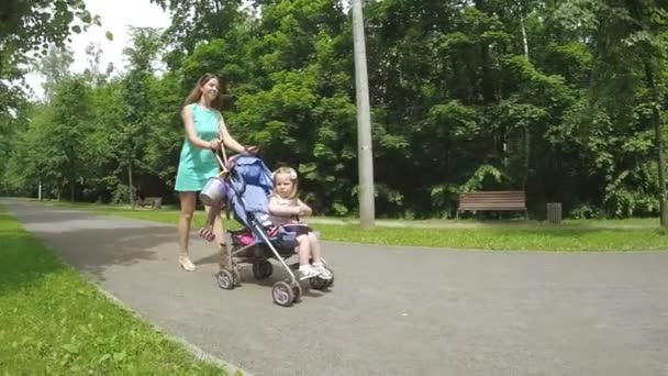 妈妈和女儿坐在婴儿车里 — 图库视频影像