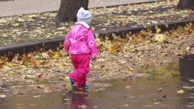 Kız çocuğu su birikintilerinde koşar