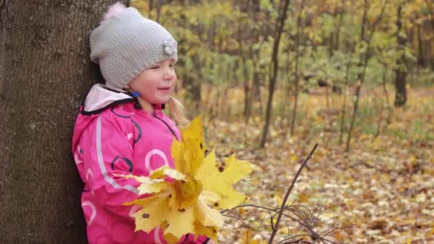 Menina bebê com folhas amarelas — Vídeo de Stock