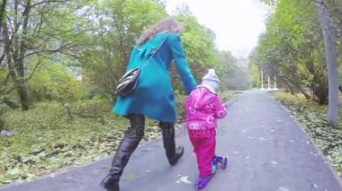 Anne ve kız motosiklete biniyor.