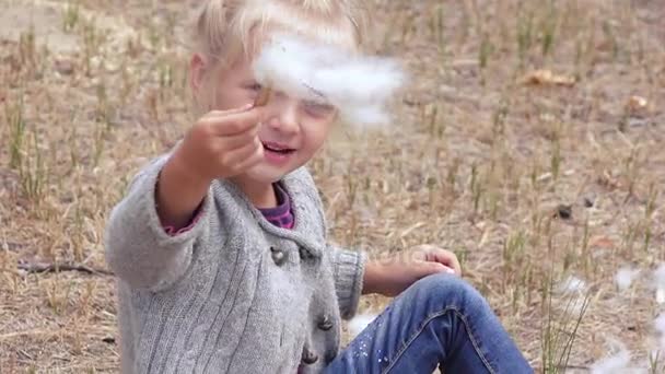 Fille enfant soufflant duvet de scirpe — Video