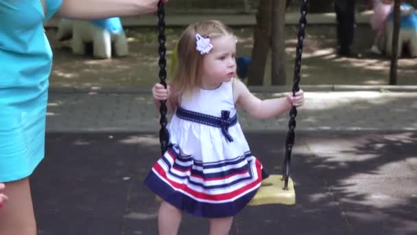 Menina montando em um balanço mãe — Vídeo de Stock