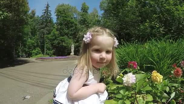 Menina criança cheirando flores — Vídeo de Stock