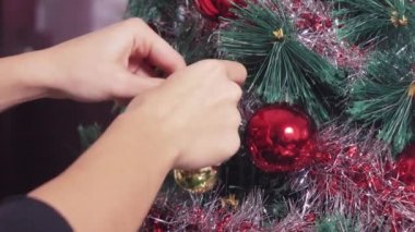 Kız Noel ağacını süslüyor.
