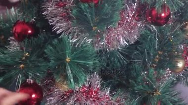 Kız Noel ağacını süslüyor.