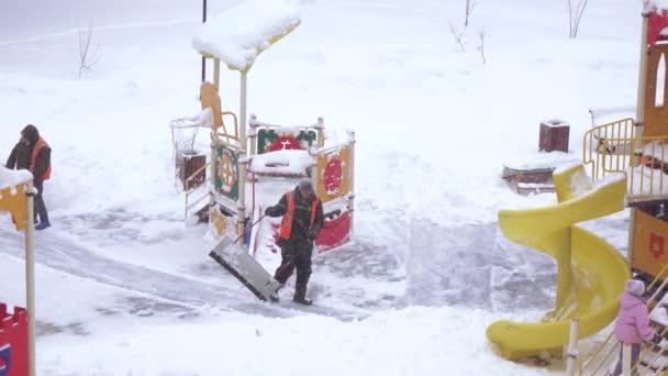 Уборка снега на детской площадке — стоковое видео