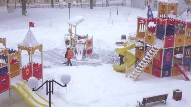 Limpeza de neve no parque infantil — Vídeo de Stock