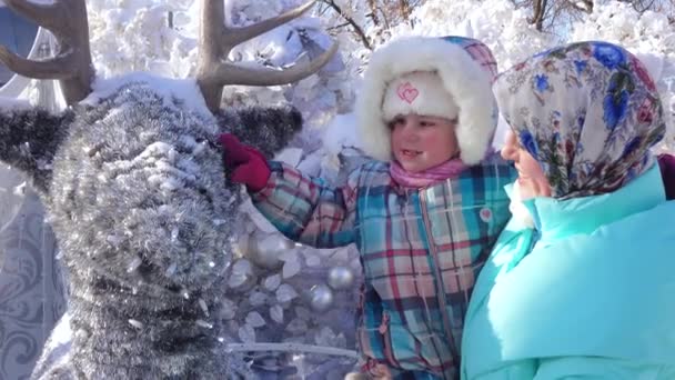 Chica con su madre acariciando un ciervo — Vídeos de Stock