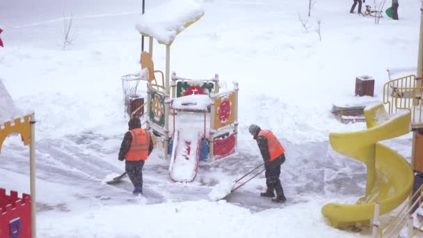 Sneeuw schoonmaken in de speeltuin — Stockvideo