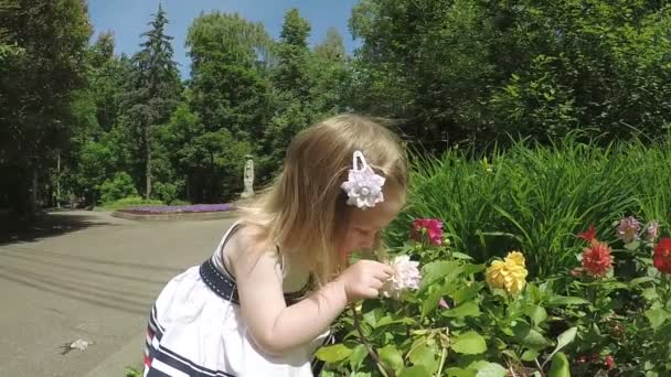 Девочка нюхает цветы — стоковое видео