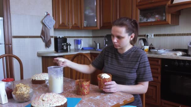 The girl covers the Easter cake with frosting — Stock Video