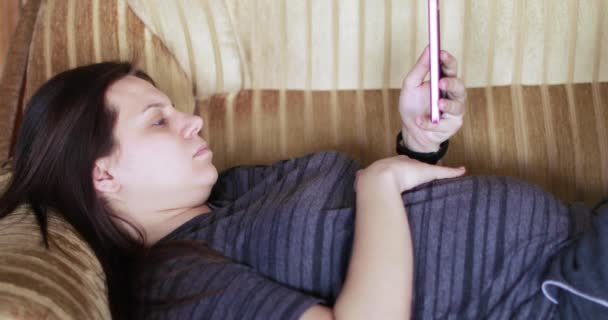 Беременная девушка со смартфоном — стоковое видео
