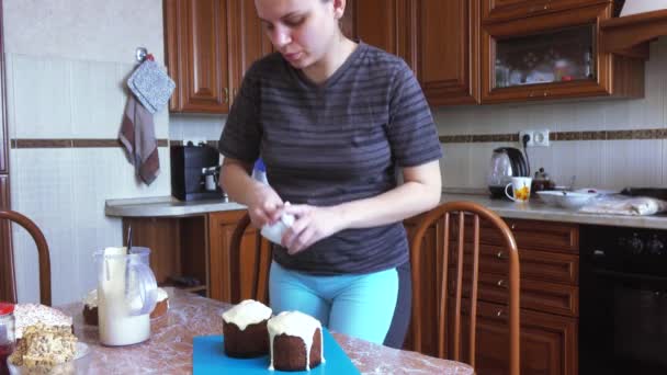 The girl covers the Easter cake with frosting — Stock Video