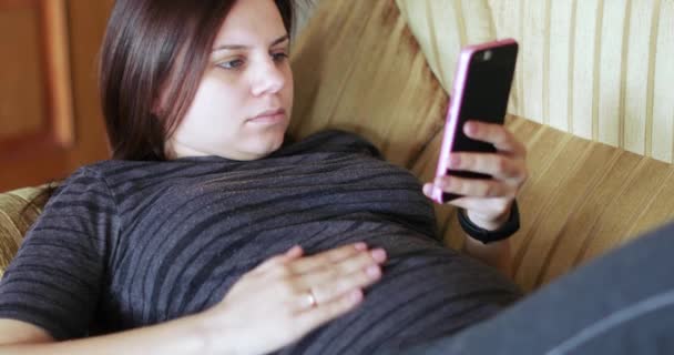 Menina grávida com um smartphone — Vídeo de Stock