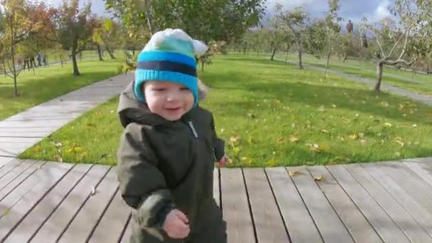 Niño pequeño pisa un césped — Vídeos de Stock