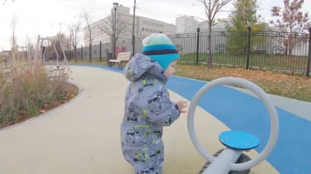 Menino de macacão no parque infantil — Vídeo de Stock