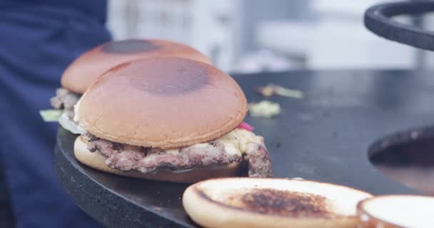 Een hamburger koken op straat — Stockvideo