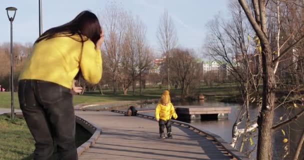 Mamá con un bebé en un muelle de madera — Vídeo de stock