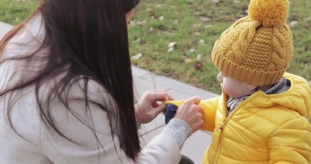 Мама с ребенком надевает перчатки — стоковое видео