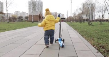 Çocuk scooter sürmeyi öğretiyor.