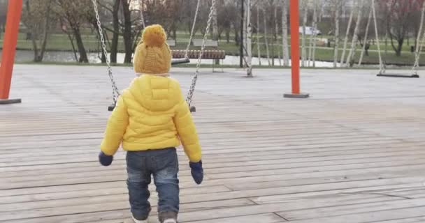 Junge schüttelt eine Kettenschaukel — Stockvideo