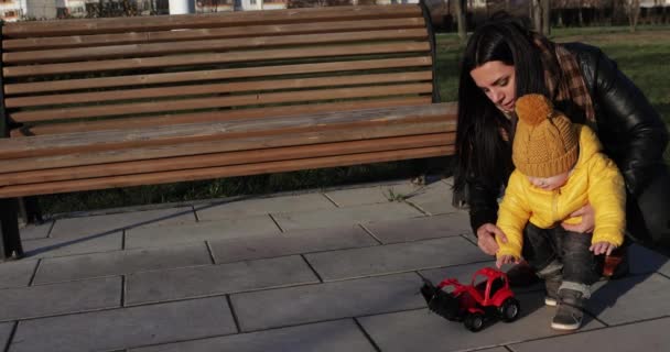 Moeder met een baby spelen graafmachine — Stockvideo