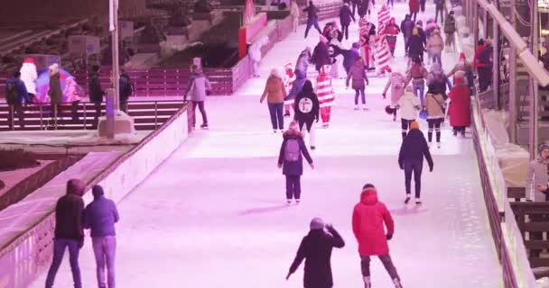 Eisbahn-Besucher und Bühnen- und Weihnachtsdekoration im Hintergrund — Stockvideo