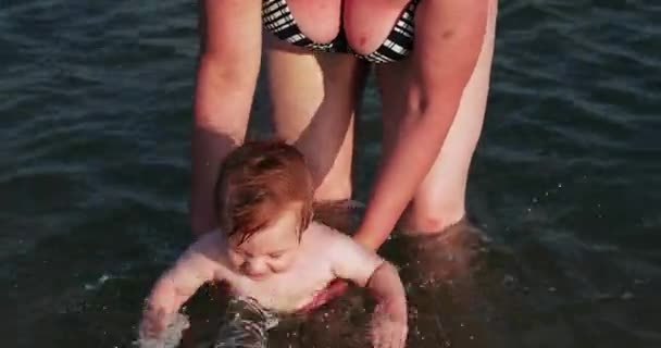 Мальчик с бабушкой в море — стоковое видео