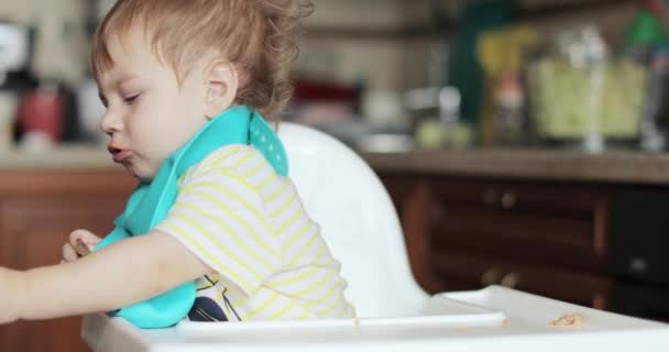 Baby jongen gevoed soep met een lepel — Stockvideo