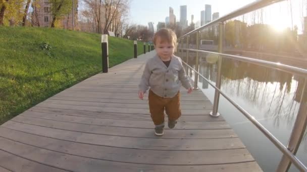 Bambino ragazzo corre su una piattaforma di legno — Video Stock