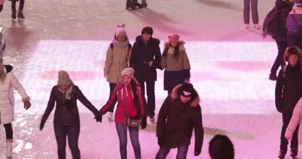 Ijsbaan bezoekers en podium en kerst decoratie op de achtergrond — Stockvideo