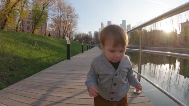 Bambino ragazzo corre su una piattaforma di legno — Video Stock